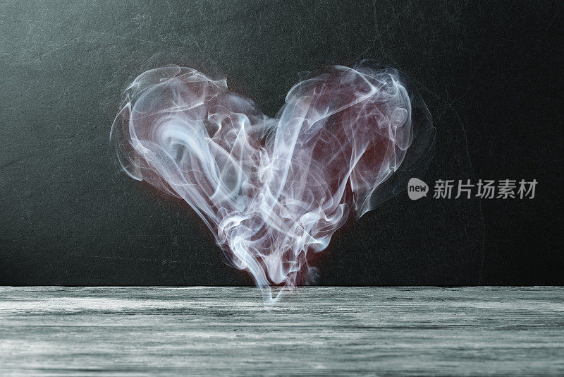 Smoke in a shape of Valentine heart over dark stone background. Valentineâs day conceptual greeting